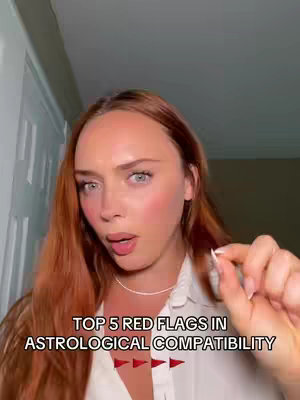 A woman with long, red hair is looking towards the camera and appears to be speaking. Text overlays introduce the topic of "Top 5 Red Flags in Astrological Compatibility."