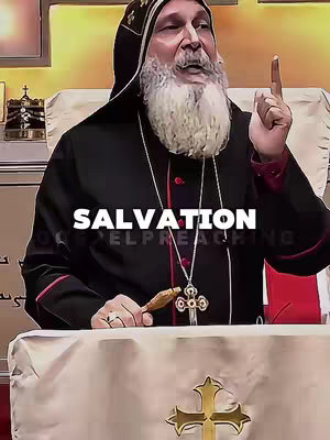 The image showcases an older man of apparent religious authority, dressed in black robes and a tall, ornate black hat. He has a long white beard and is gesturing upwards with his right index finger. The background is blurred, but suggests an indoor setting. Overlayed on the image is the word 'SALVATION' in bold, white text, partially obscuring the man’s figure.