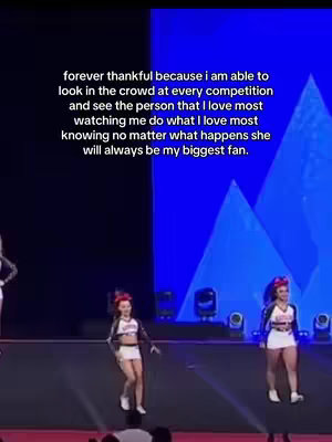 Three cheerleaders performing on a stage. The background is a dark blue with some light reflections. The cheerleaders are wearing matching outfits, white skirts and tops with jackets. Text is overlaid on the image.