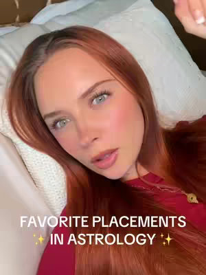 The cover image features a young woman with long red hair and light eyes, lying on a white pillow. She is wearing a red top and a gold necklace. The text overlay at the bottom reads "FAVORITE PLACEMENTS ✨ IN ASTROLOGY ✨" in white font.