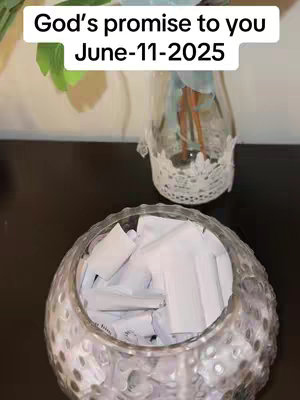 The cover image displays a tabletop scene. A clear glass jar sits in the foreground, filled with rolled-up white papers. A smaller, decorative vase with flowers is positioned behind it, to the right. The image has soft lighting and a neutral, natural color palette.