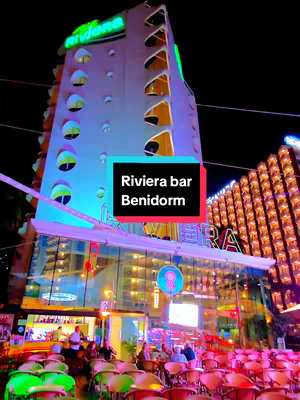 A night time shot of the side of a high-rise hotel, brightly lit with many windows. Text overlayed on the image.