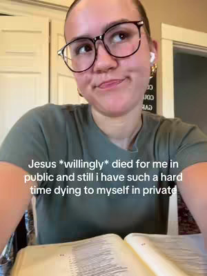 A woman with glasses and a thoughtful expression is looking up. She is wearing a green shirt and has earbuds in. In the foreground is an open book. Overlay text states: Jesus *willingly* died for me in public and still i have such a hard time dying to myself in private.