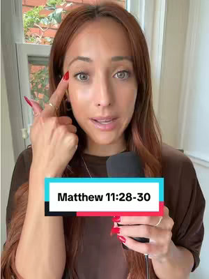 A woman with long auburn hair points at her eye with her index finger, looking towards the camera. Below her is a rectangle with 'Matthew 11:28-30' written in white.