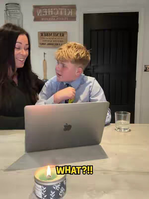 A woman and a boy are facing each other over a laptop on a kitchen counter. The hook text "WHAT?!!" is overlaid on a lit candle in a jar.