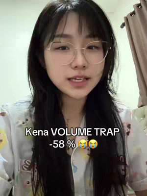 A woman with black hair and glasses is looking directly at the camera expressing emotion. Overlayed on the screen is text with a percentage indicating a financial loss, and two emoji.