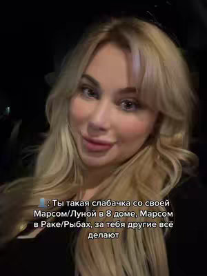A selfie-style video cover image featuring a fair-skinned woman with long, wavy blonde hair. She has visible blush on her cheeks and is smiling slightly, with visible teeth. Overlayed text is present at the bottom of the video.
