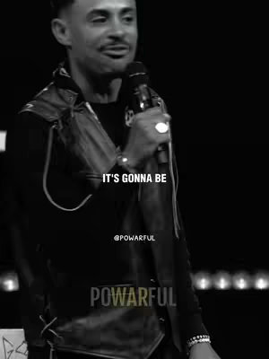 A monochrome image of a man in a vest and holding a microphone, with overlay text.