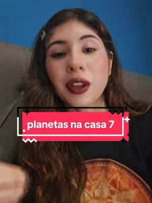 A woman with long brown hair is centered, looking directly at the camera. She's wearing minimal makeup with red lip color, in focus against a blurry background. A text box overlaps, indicating an astrology theme.