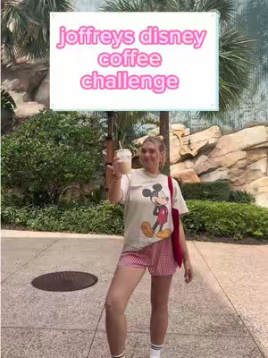 A woman stands outdoors at a Disney location, holding a drink. She is wearing a Mickey Mouse t-shirt, red checkered shorts, and has a bag over her shoulder, holding a drink. A large sign-like overlay with text is above her head.