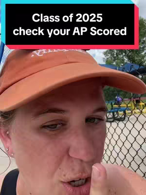 A person wearing an orange cap is shown from the chest up, addressing the camera. Above them is a black banner with white text. Behind the person is a chain-link fence and a blurry outdoor setting.