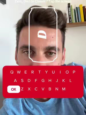 A selfie-style shot featuring a man's face at eye level, with a stylized outline of a soda can superimposed over his forehead. The text 'Zero, Diet or Classic? Tap the screen'is written on the top of the image, and a red keyboard interface at the bottom allows input using keys. The main color is red, with the man's top being a blue color.