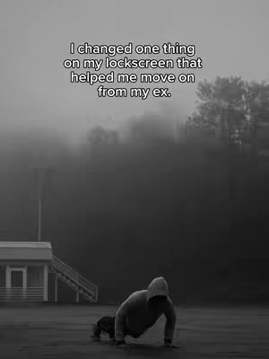 A black and white image shows a person in a hooded sweatshirt doing push-ups outdoors. The background is obscured by fog or mist. Text at the top reads, 'I changed one thing on my lockscreen that helped me move on from my ex.'