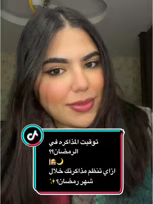 A woman with dark hair and makeup is centered in the frame, smiling at the camera. The background is slightly blurred, with neutral tones suggesting an indoor setting. Overlayed on the image is a black box containing text in Arabic and various emojis, including a crescent moon and mosque. The TikTok logo is in the lower left corner.