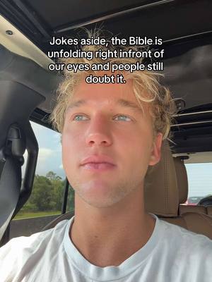 A selfie-style image featuring a young man looking slightly up, with text overlaid above his head. He has light skin, blonde hair, and is wearing a white t-shirt. The background shows the interior of a car, with a view of greenery outside the window.