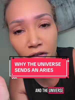 A woman with light skin and light-colored hair is centered in the frame, looking towards the viewer with a slightly open mouth. A red rectangular text overlay shows the words "WHY THE UNIVERSE SENDS AN ARIES" in white, bold font. Below, the words "AND THE UNIVERSE" are visible in black text. The background appears blurred with indistinct shapes and colors.