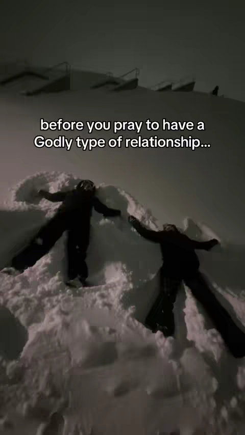 Two people, likely in a snowy outdoor setting, are making snow angels. The sky is dark. Text overlayed on the image provides context to the scene, and is placed in the upper portion over grey.