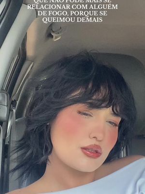 The cover image features a woman inside a car, seen from the chest up. The woman has dark, choppy hair and is wearing a white top. She has makeup on with pink blush.  Text is overlaid at the top of the image.