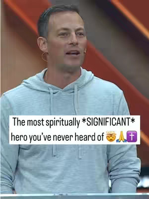 The cover image features a man in a light blue hoodie speaking, set against a reddish-orange background. A text overlay at the bottom reads "The most spiritually *SIGNIFICANT* hero you've never heard of" followed by emojis. The composition is centered on the man, with the background providing a warm, contrasting context.