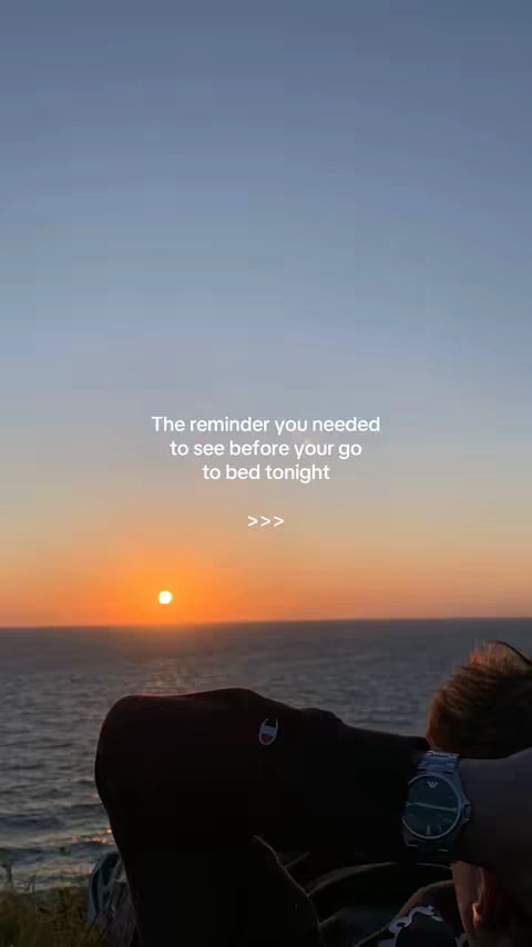A serene image showing a sunset over the ocean. The sky transitions from blue to orange and a partial view of a person is in the foreground, with a Champion sweatshirt and a watch. Text is overlaid on the middle of the image.