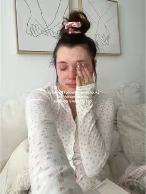 The cover image shows a woman with dark hair pulled up in a bun, crying while holding her hand up to her face. She is wearing a white patterned top and is sitting on a bed, with a framed artwork visible in the background.