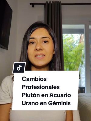 A woman with dark hair and a white shirt is in a home setting. She is speaking and a white rectangle with black text blocks part of her body. The text says "Cambios Profesionales Plutón en Acuario Urano en Géminis."