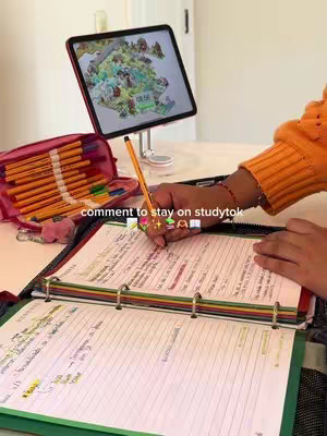 The cover image shows a person's hands writing in a notebook. An open binder-style notebook is on the table, with pages filled with notes and highlighting. In the background, a tablet rests on a stand, displaying a map. The person's hand with a pen is in the foreground positioned for writing. The background is a blurred domestic setting.