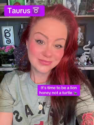 A woman with auburn hair and a light green t-shirt smiles at the camera; overlaid text frames read Taurus and It's time to be a lion honey not a turtle; an eclectic shelf is visible in the background.