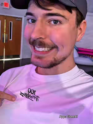 The cover image shows MrBeast, smiling and looking directly at the camera. He is wearing a gray cap, with a white t-shirt with a logo on it and is pointing his finger to the logo. The background shows a doorway.