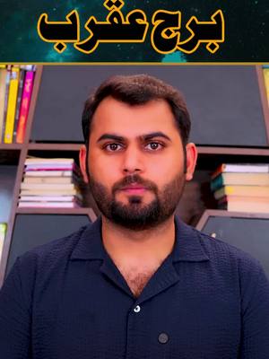 A medium shot featuring a man with a beard and dark short hair, positioned against a backdrop of bookshelves. At the top, a golden banner has text written in a script that looks like Arabic. He is centered in the frame and looking directly at the camera with a neutral expression. He is dressed in dark blue shirt. The color palette is muted, with subtle lighting. The overall composition is straightforward.