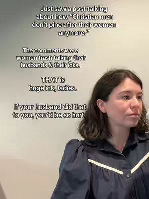 A woman with dark hair and a navy blue top is facing the camera, slightly off-center. Text overlays are present, and the background is a simple wall. The woman appears to be talking.