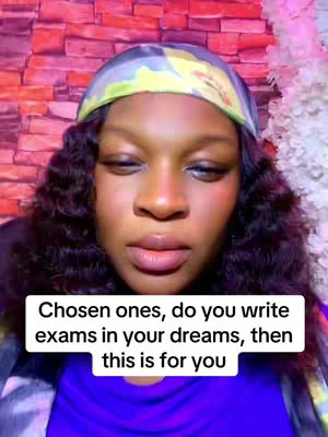 A woman with dark curly hair, wearing a headband and a blue top, is looking down. Overlayed text on a white bar at the bottom states: "Chosen ones, do you write exams in your dreams, then this is for you". The background includes a brick wall look on the background and a feathery or floral touch.