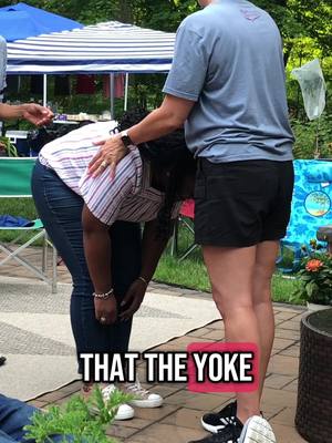 The image shows two women standing outside, one touching the other's back with a hand. Text overlayed at the bottom: "THAT THE YOKE."