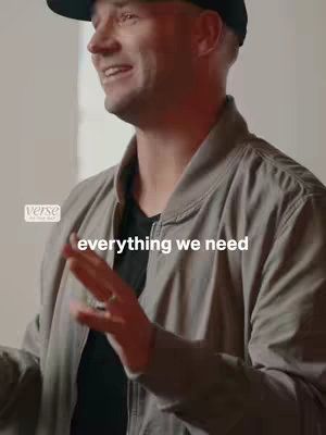 A man wearing a black cap and a light gray bomber jacket is speaking. Text overlayed states "everything we need."