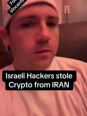 A medium shot shows a young man in a white cap and shirt, looking slightly downward. Text overlays read 'For Vincents' and 'Israeli Hackers stole Crypto from IRAN'. The image has a reddish hue, suggesting dim lighting.