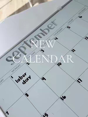 A close-up shot of a calendar, with "September" printed in large, gray letters across the top. The current date, "Labor Day" on the first, is carefully handwritten in black ink, standing out against the lighter gray background. The layout features gray printed numbers to show the days of the month.