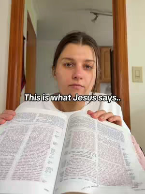 A woman holds an open Bible, looking directly at the camera. Overlayed text reads 'This is what Jesus says..'. The background includes a wooden door frame and hints of a room.