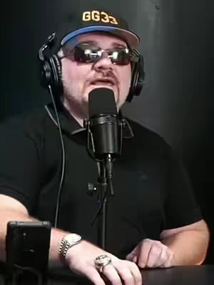 The cover image features a man wearing sunglasses, a black shirt, and a cap that says "GG33". He is holding a microphone in a podcasting setup. The background is dark, and the overall composition focuses on the man from the chest up.