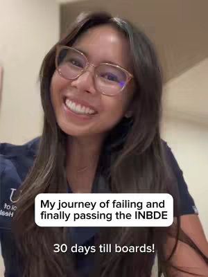 A smiling young woman with glasses, wearing a dark blue top, is the focus of the image. Text overlays on the image read 'My journey of failing and finally passing the INBDE' and '30 days till boards!'. The background is slightly blurred, suggesting an indoor setting, with a warm, neutral color palette.