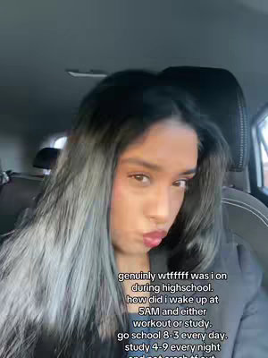A selfie of a person inside a car. The person is looking at the camera with pursed lips. The hair is dark with grey highlights. Text is overlaid on the image describing a past lifestyle.