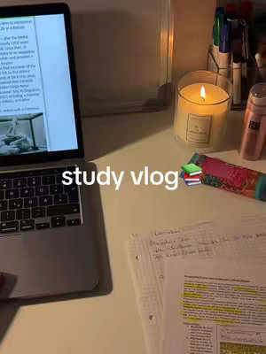 The cover image shows a desk setup with a laptop on the left, displaying text on the screen. To the right is a lit candle, pens, a book with sticky notes, and some papers containing highlighted notes. The overall lighting suggests it's a nighttime study session.
