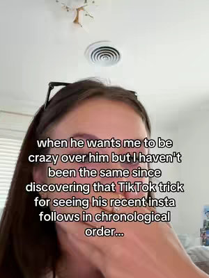 The image shows a close-up of a woman's face with text overlays. The top half of the image shows the ceiling and a light fixture. The woman's face takes up the bottom half. She has dark hair and is wearing dark-framed glasses pushed up on her forehead. She is looking down and slightly to the side, with a hand partially covering her face. The text overlays are in black and white. The overall composition is simple.