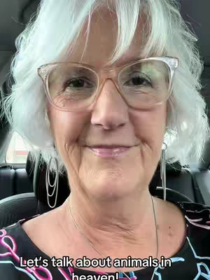 An older woman with short, white hair and glasses is smiling at the camera. She's wearing a patterned top, and text at the bottom reads "Let's talk about animals in heaven!".