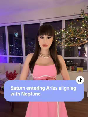 A woman stands in front of a window with city lights visible outside. She is wearing a pink dress and a text overlay describing planetary alignment. A tree with lights is to the right of the image.