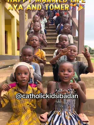 A group of children, some smiling, are gathered on a staircase. Two children in the foreground are pointing towards the camera. Text overlays the image.