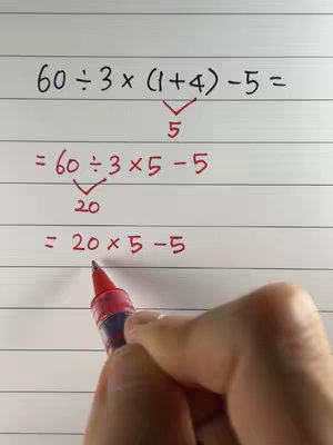 A hand is holding a red pen, pointing at a handwritten math problem on lined paper. The problem is written in black ink,  with solutions and arrows added in red.