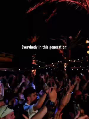 A nighttime shot showing a crowd of people in an outdoor setting, likely at a music venue or event. The foreground is filled with people raising their arms, with many holding up phones to record the scene. Above, the text overlay reads. The background is dimly lit, featuring palm trees and string lights, creating a festive atmosphere. The overall composition is dark with vibrant pops of light from the stage or surrounding buildings.