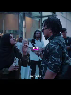 A scene from an outdoor setting with diverse people. A person with dreadlocks and sunglasses is holding a microphone and talking to a person wearing a hijab. The background includes other people.