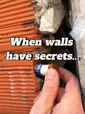 The cover image shows a close-up of a wall with orange bricks, partially damaged to reveal a hidden compartment. A hand holds a small container, presumably a geocache, placed within the secret space.