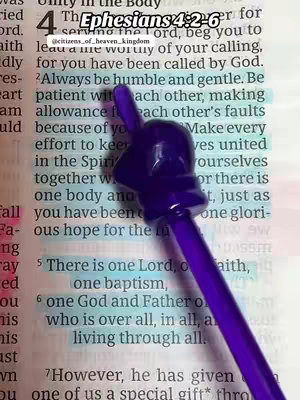 The image shows an open Bible with highlighted text and a purple pen placed over it. The top of the page features the text 'Ephesians 4:2-6' in a stylized font, with the chapter and verse numbers highlighted in blue. The pen, with a distinctive purple shape at its top, slightly obscures the text. The background is a page from the Bible, with the text in a traditional font.